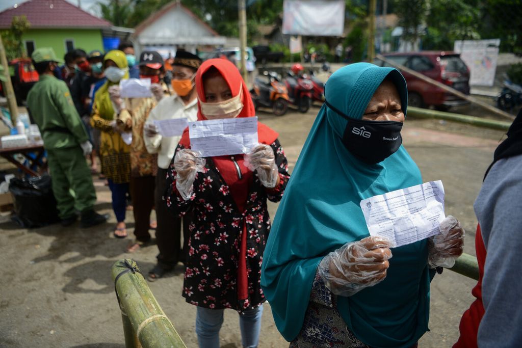 Warga menunjukkan undangan untuk memilih sebelum menggunakan hak pilihnya dalam Pilkada di TPS 06, Desa Tlogolele, Selo, Boyolali, Jawa Tengah, Rabu (9/12/2020). 