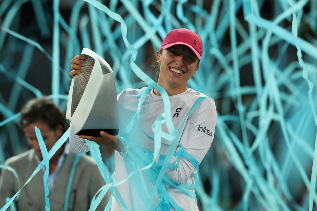 Iga Swiatek memegang trofi juara WTA 1000 Madrid setelah mengalahkan Aryna Sabalenka pada partai final di La Caja Magica, Madrid, Sabtu (4/5/2024). 