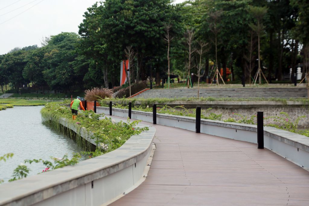 Petugas merapikan tanaman di samping jalur pedestrian setelah revitalisasi di Taman Mini Indonesia Indah, Jakarta, Selasa (15/11/2022). Revitalisasi TMII mengusung tema dan konsep baru, yakni kawasan wisata rendah karbon dan ramah lingkungan.  