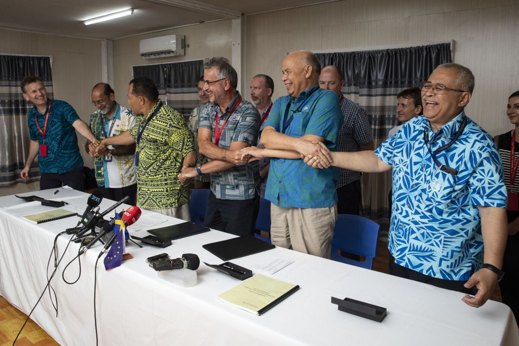 Anggota kelompok masyarakat dan nelayan Pasifik bergandengan tangan setelah menandatangani kesepakatan dalam Forum Kepulauan Pasifik di Nauru, Rabu, 5 September 2018. Mereka menandatangani kesepakatan dengan Uni Eropa untuk meningkatkan tata kelola perikanan dan kelautan yang berkelanjutan di kawasan tersebut. 