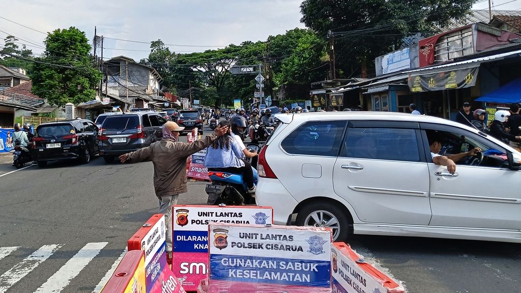 Pengendara mobil memutar balik kendaraannya untuk menghindari kemacetan, di Jalan Raya Ciawi, Sabtu (13/4/2024). Mobil ini sudah dua kali berusaha putar balik untuk mencari atau mengindari kemacetan di kawasan Puncak Bogor.