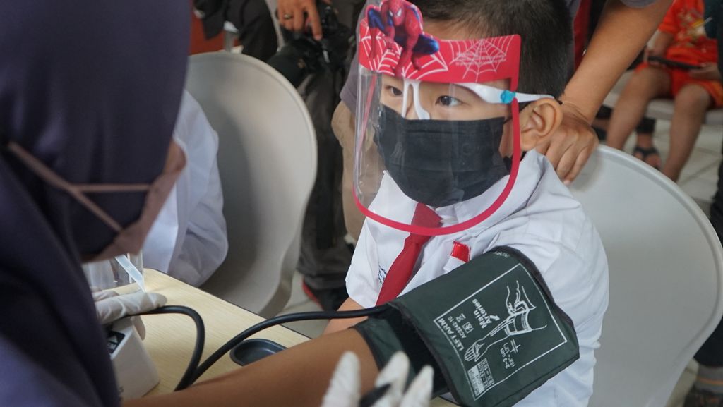 Siswa SD Negeri 2 Palembang diperiksa sebelum menjalani vaksinasi untuk anak usia 6-11 tahun, Jumat (14/1/2022). Vaksinasi ini penting untuk mengurangi risiko tertular Covid-19 atau menekan angka kematian dan kesakitan akibat terjangkit penyakit tersebut.