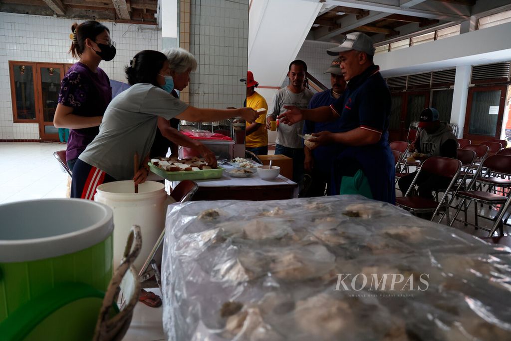Sukarelawan membagikan makanan dan minuman saat acara kantin kebajikan di Gedung Rasa Dharma, kawasan pecinan, Kota Semarang, Jawa Tengah, Selasa (13/6/2023). Kegiatan sosial yang diselenggarakan setiap pekan oleh komunitas Tionghoa ini membagikan makanan dan minuman secara gratis bagi warga tidak mampu di sekitarnya. 