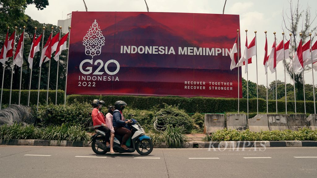 Warga melintasi baliho G-20 di kawasan Tanah Abang, Jakarta Pusat, Selasa (1/2/2022).