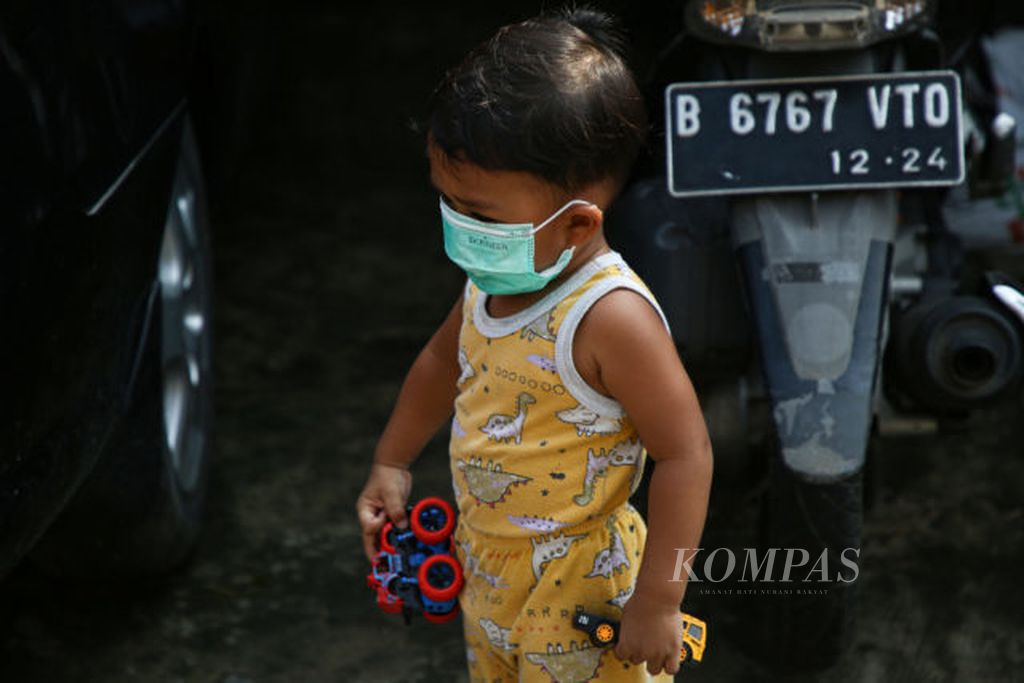 Seorang anak bermain dengan mengenakan masker di lingkungan RT 002 RW 003, Larangan, Kota Tangerang, Banten, Selasa (29/6/2021). Anak-anak menjadi kelompok yang rentan tertular Covid-19. Pemerintah membuka opsi vaksin bagi anak usia 12-17 tahun.