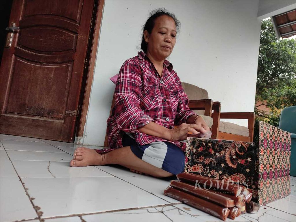 Nanih (51) menunjukkan cara membungkus dodol betawi di rumahnya, Senin (24/4/2023). Saat Lebaran, warga betawi yang bermukim di Cilodong, Depok, Jawa Barat, itu bersilaturahim dengan kerabatnya dengan jarak hanya beberapa kilometer.