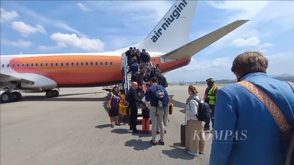 Para wartawan menuju pesawat Boeing 737-800 NG Air Niugini. Paus Fransiskus akan terbang menggunakan pesawat yang sama dengan para wartawan dari Bandara Internasional Jackson, Papua Niugini, Senin (9/9/2024).