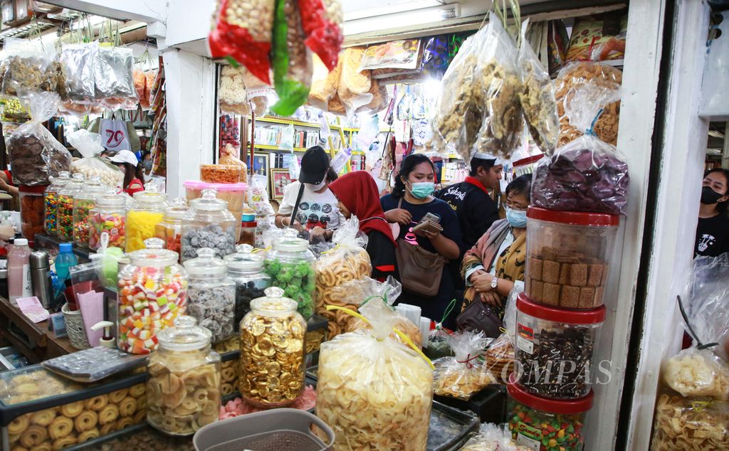 Pengunjung menunggu giliran untuk dilayani di toko kue Sukajadi di Pasar Jatinegara, Jakarta Timur, Selasa (20/12/2022). Penjualan kue kering mulai dari pasar tradisional, pusat perbelanjaan, hingga penjualan daring di lokapasar mengalami peningkatan.