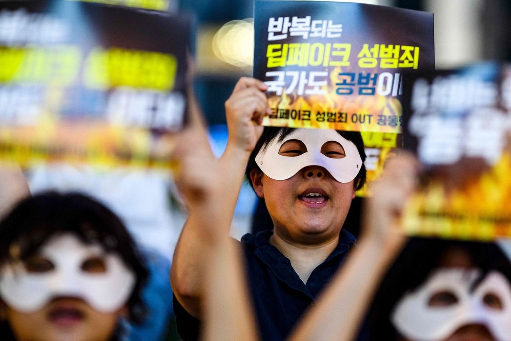 Para aktivis, dengan mengenakan topeng mata, berunjuk rasa menentang pornografi <i>deepfake</i> di Seoul, Korea Selatan, 30 Agustus 2024. Poster yang mereka angkat bertuliskan ”Kejahatan seks <i>deepfake </i>terus berulang, negara ikut bertanggung jawab”. 