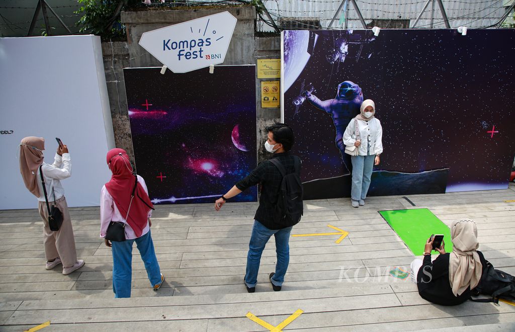 Para pengunjung berswafoto di lokasi acara Kompasfest Presented by BNI 2022 di M Bloc Space, Jakarta Selatan, Jumat (19/8/2022).