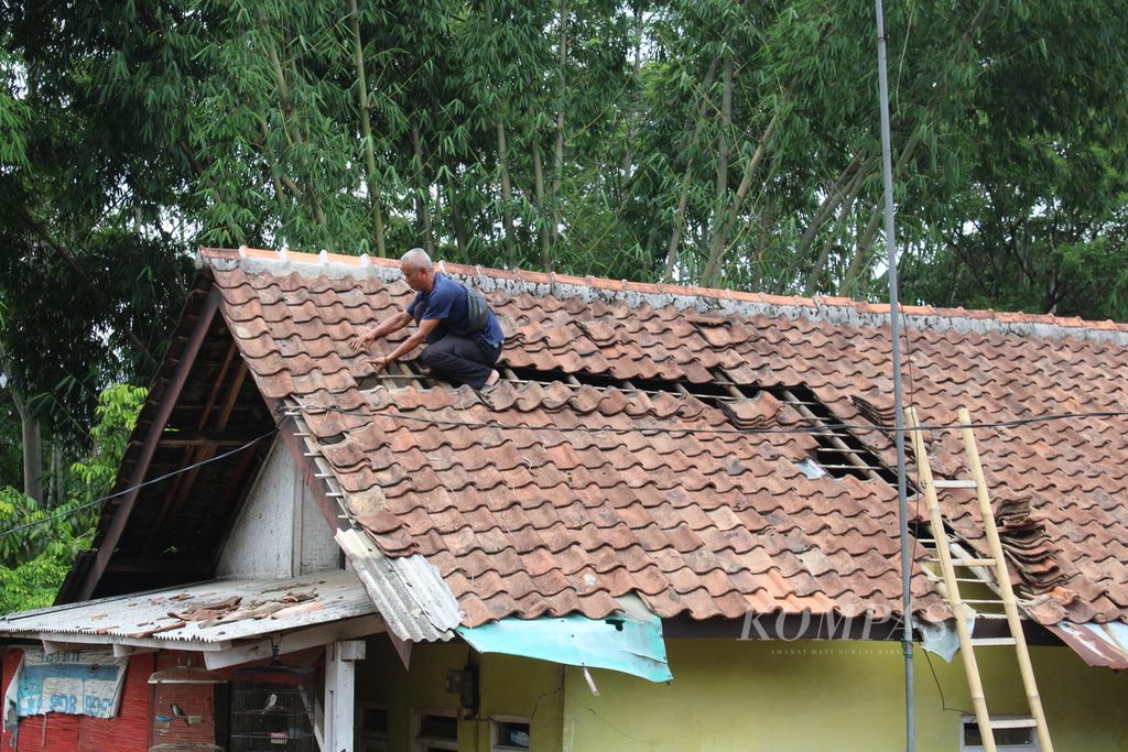 Warga memperbaiki genteng rumahnya yang rusak akibat gempa yang melanda di Kelurahan Cipameungpeuk, Kecamatan Sumedang Selatan, Sumedang, Jawa Barat, Senin (1/1/2024). Ratusan rumah mengalami kerusakan akibat gempa dangkal yang melanda Sumedang di pengujung 2023.