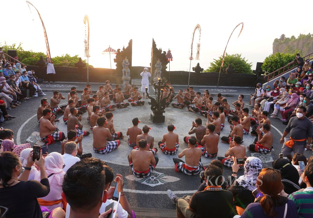 Pengunjung menggunakan masker saat menonton pertunjukan tari Kecak di kawasan Pura Luhur Uluwatu, Kabupaten Badung, Bali, Kamis (24/3/2022). Dalam kesempatan itu, sekitar 1.000 penonton hadir. Normalnya, sebelum pandemi ada lebih kurang 3.000 penonton tari Kecak dalam sehari. Karena keterbatasan tempat, pertunjukan digelar sebanyak dua kali sehari.