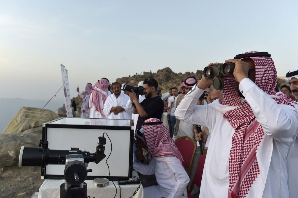 Warga Arab Saudi melihat ke langit untuk melihat bulan sabit pertama yang menandai dimulainya bulan suci Ramadhan, di kota Taif di barat daya Saudi pada 1 April 2022. 
