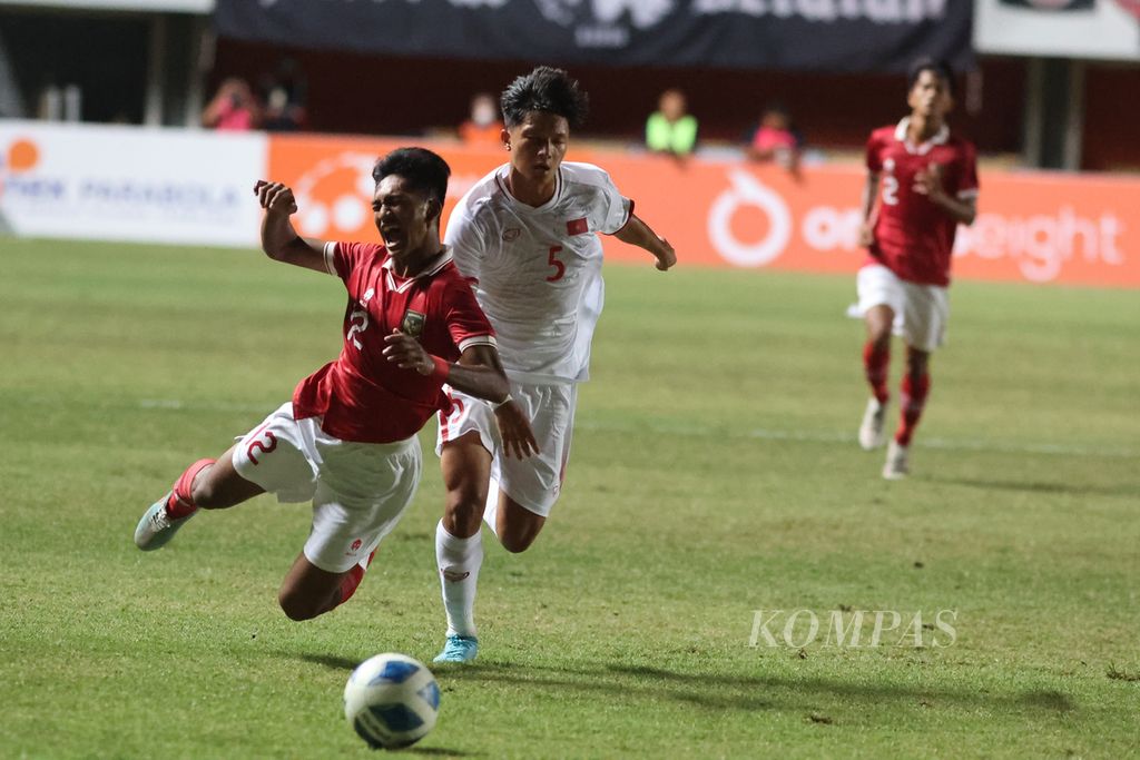 Pemain Tim Indonesia U-16 Narendra Tegar Islami (kiri) terjatuh saat berebut bola dengan pemain Tim Vietnam U-16 Khuc Trung Hieu dalam laga Piala AFF U-16 di Stadion Maguwoharjo, Sleman, DI Yogyakarta, Sabtu (6/8/2022). Indonesia menang 2-1 pada laga itu. 
