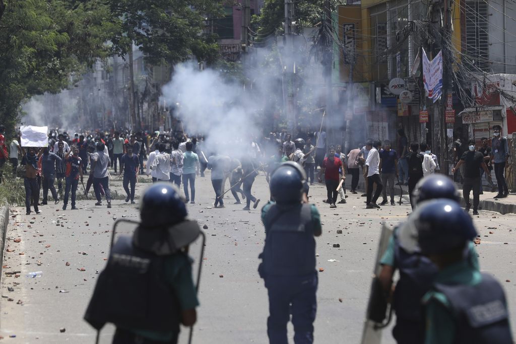 Mahasiswa bentrok dengan polisi anti huru hara saat protes terhadap sistem kuota pekerjaan pemerintah, di Dhaka, Bangladesh, Kamis (18/7/2024). 