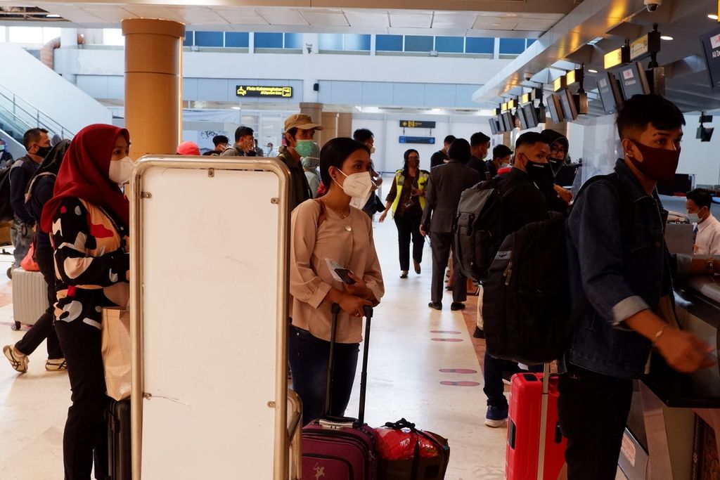 Calon penumpang tetap menggunakan masker dan menjaga jarak saat melakukan pelaporan di konter salah satu maskapai di Bandara Internasional Lombok, Lombok Tengah, Nusa Tenggara Barat, Jumat (8/1/2021).