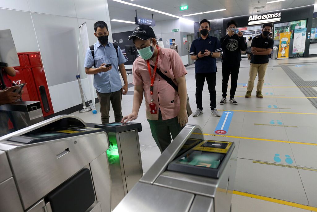 Rombongan jurnalis menempelkan kartu JakLingko pada mesin pemindai pada pintu otomatis saat uji coba penggunaan kartu tersebut di Stasiun MRT Bundaran HI, Jakarta Pusat, Senin (4/10/2021). 