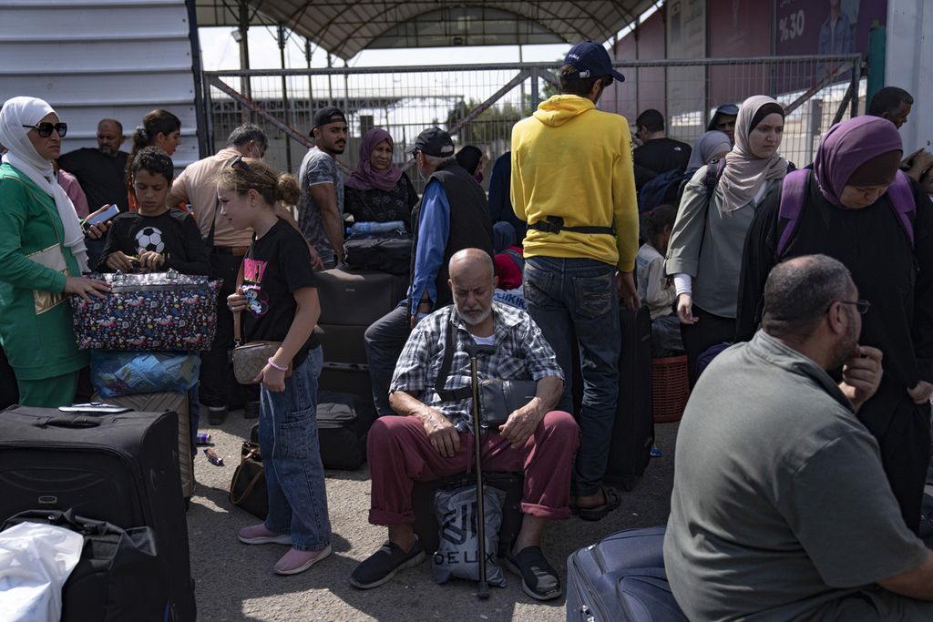 Pengungsi Palestina duduk menunggu dibukanya akses menuju Mesir dari perbatasan Rafah di Jalur Gaza, Senin (16/10/2023) .  