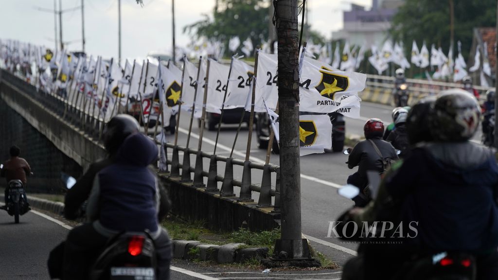 Pengendara melintasi bendera Partai Ummat di Pondok Bambu, Jakarta Timur, Senin (13/2/2023). Partai politik tengah melakukan sosialisasi dengan memperkenalkan diri kepada masyarakat. 