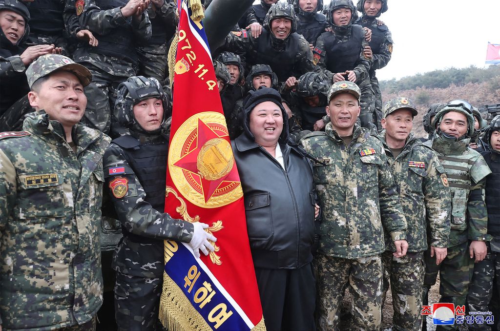 Foto yang diambil pada 13 Maret 2024, Pemimpin Korea Utara Kim Jong Un (tengah) berfoto bersama para prajurit Divisi Tank Ke-105 Seoul Ryu Kyong Su Guards di lokasi latihan yang dirahasiakan. 