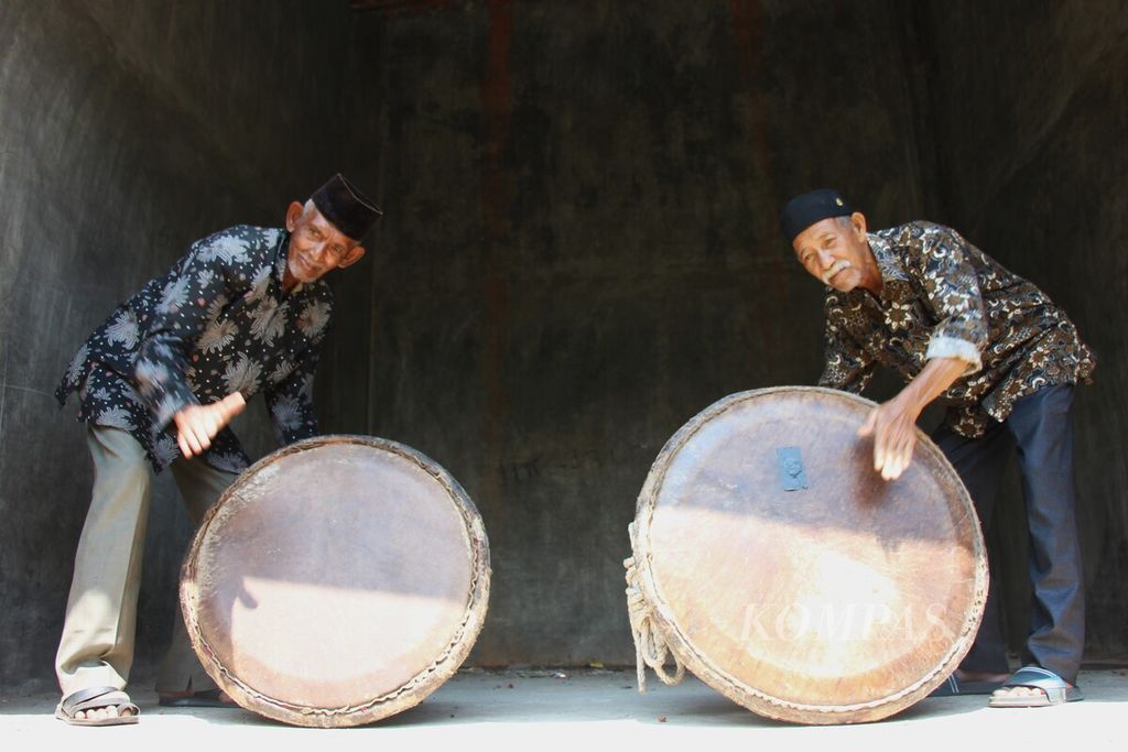 Dua pemain rapai pasee, Nasruddin (69) dan Teuku Muhammad Daud (88), berfoto dengan rapai pasee pada Rabu (22/6/2023) di Desa Glumpang VII, Kecamatan Matang Kuli, Kabupaten Aceh Utara. Keduanya adalah tokoh yang melestarikan kesenian rapai pasee.