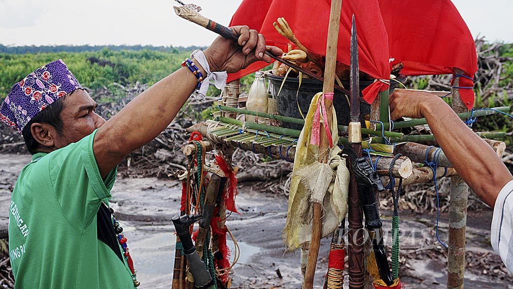 Upu Ucun Tirunuk, basir atau pemuka agama Kaharingan, kepercayaan masyarakat suku Dayak,  memulai upacara adat hinting pali di Desa Lawang Uru, Kabupaten Pulang Pisau  (foto bawah).