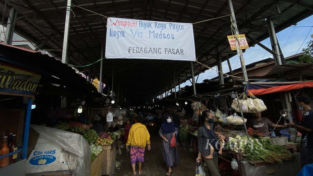 Spanduk ajakan untuk mewaspadai praktik pinjaman <i>online </i>(pinjol) ilegal menghiasi pintu masuk Pasar Muara Angke, Penjaringan, Jakarta Utara, Minggu (14/11/2021). 