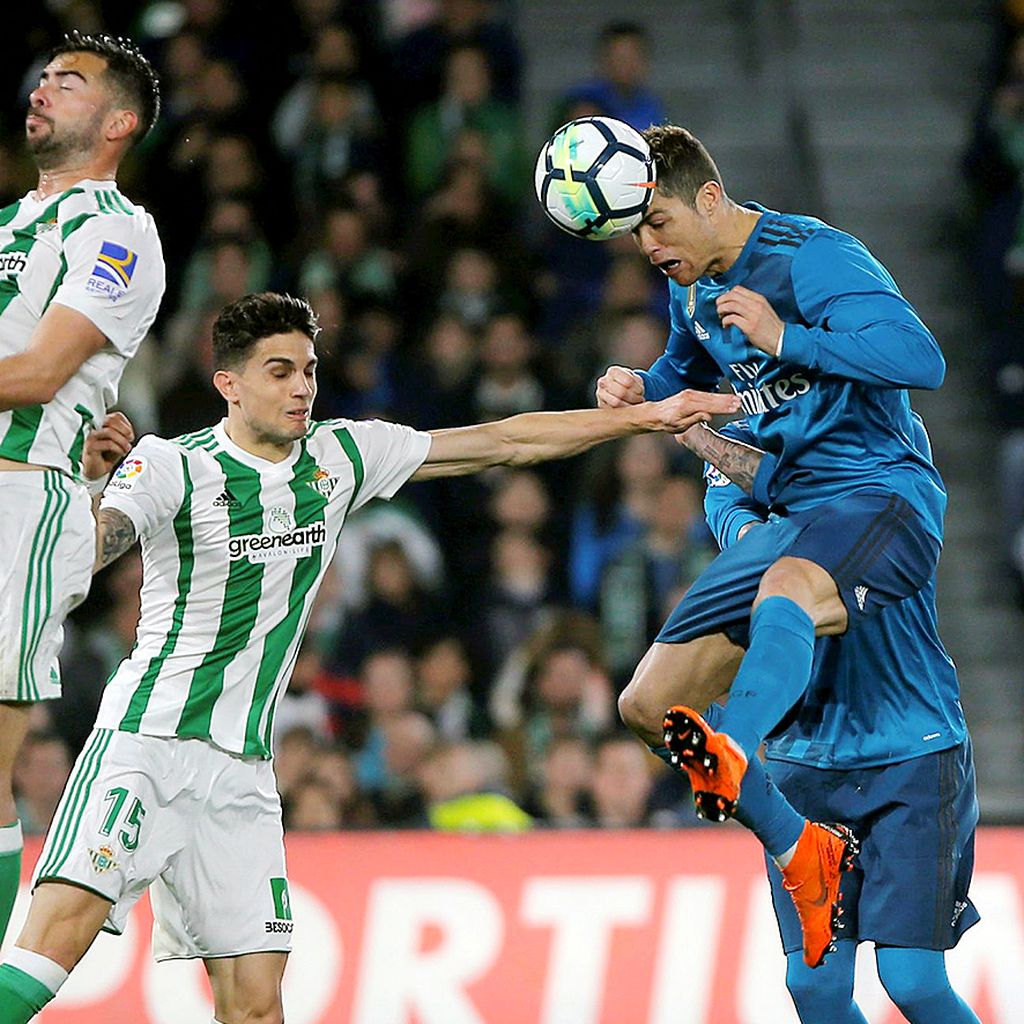 Cristiano Ronaldo, pemain serang Real Madrid, menyundul bola saat berusaha menceploskan gol ke gawang Real Betis pada laga Liga Spanyol di Stadion Benito Villamarin, Seville, Senin (19/2) dini hari WIB. Real Madrid menang 5-3. 