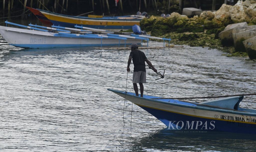 Nelayan bersiap melemparkan jangkar dari atas perahu di dermaga Pasar Ikan Fandoi, Kabupaten Biak Numfor, Papua, Jumat (1/10/2021). 