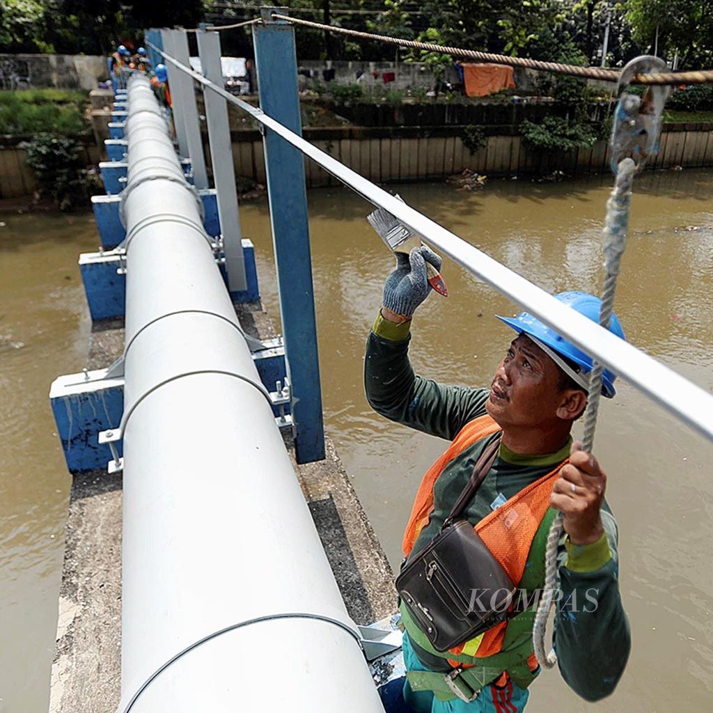 Pekerja membersihkan area pipa air PT PAM Lyonnaise Jaya (Palyja) dari coretan di atas Kali Ciliwung, Jakarta, Senin (1/8/2016). Selain membersihkan coretan, kegiatan tersebut juga untuk merawat pipa agar terhindar dari karat.
