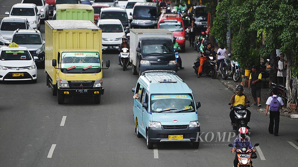 Angkutan kota M25 Grogol-Kota saat melintas di Jalan Latumeten, Jakarta, Rabu (29/11). Pemerintah Provinsi DKI Jakarta akan mulai menerapkan sistem One Karcis One Trip (OK Otrip) dengan tarif Rp 5.000 untuk tiga jam perjalanan. Untuk jangka pendek, ada 4 trayek yang akan menerapkan OK Otrip, yaitu Grogol M25, trayek baru Lebak Bulus, Marunda (U02), dan Warakas (JU 03), serta   Duren Sawit.