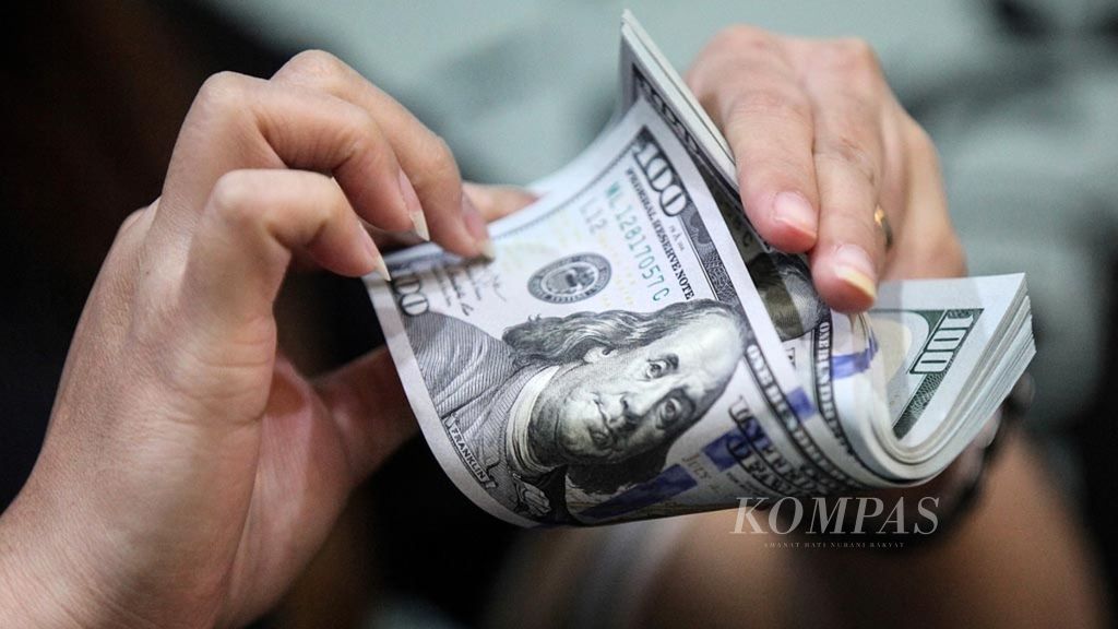 Petugas menghitung dollar AS di tempat penukaran valuta asing PT D8 Valasindo di kawasan Gandaria, Jakarta Selatan, Jumat (19/4/2019).