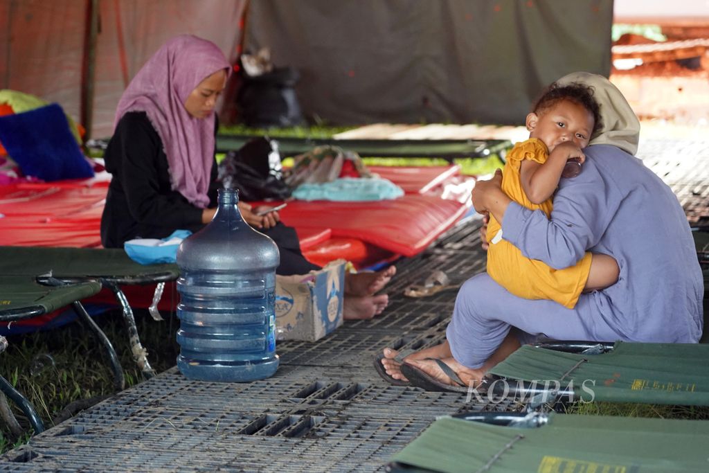 Warga Kampung Curug, Desa Bojong Koneng, Kecamatan Babakan Madang, Kabupaten Bogor, Jawa Barat, berada di tenda pengungsian bersama keluarganya yang mengungsi akibat tanah bergerak, Rabu (21/9/2022).