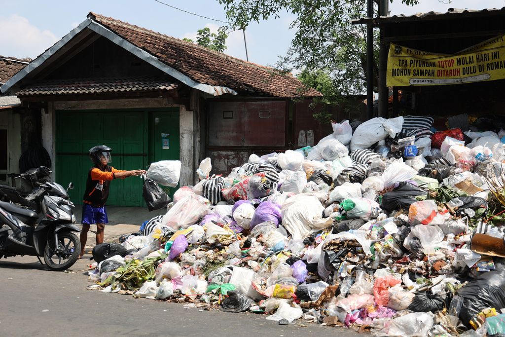 Sampah menumpuk hingga hampir memenuhi separuh ruas jalan di kawasan Lempuyangan, Yogyakarta, Senin (10/5/2022). Tumpukan sampah terlihat di sejumlah lokasi di Yogyakarta pascapenutupan Tempat Pembuangan Sampah Terpadu (TPST) Piyungan oleh warga sejak 7 Mei 2022. 