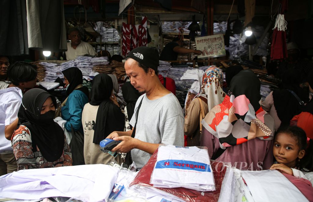 Traders are accepting payment for school uniform purchases with Jakarta Pintar card at Jatinegara market, East Jakarta, on Friday (7/7/2023). Jakarta Pintar card is considered very helpful for beneficiary students to buy uniforms and school supplies during the new academic year like now.