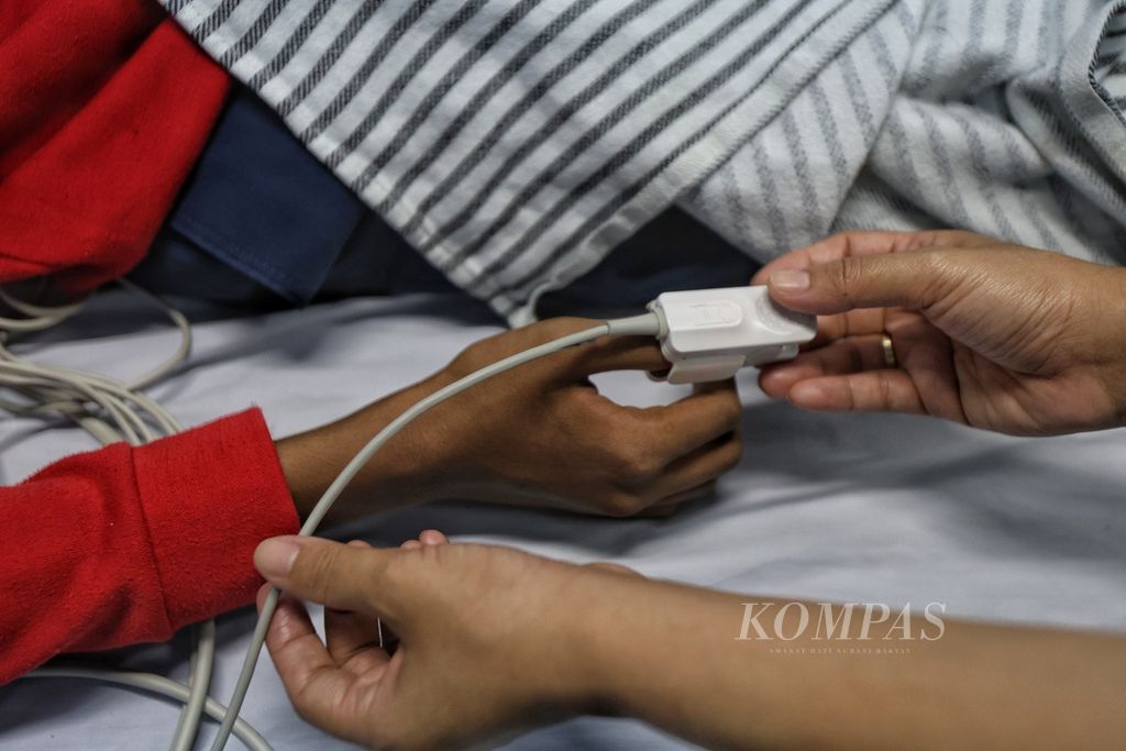 A nurse checks the condition of a patient with dengue hemorrhagic fever who is being treated at Taman Sari Regional Hospital, Jakarta, Tuesday (16/4/2024).