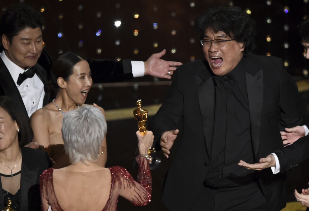 Sutradara Bong Joon Ho (kanan) bereaksi ketika menerima Oscar katagori Film Terbaik untuk filmnya, <i>Parasite, </i>dari presenter Jane Fonda pada Minggu (9/2/2020) di Dolby Theatre, Los Angeles, Amerika Serikat. 