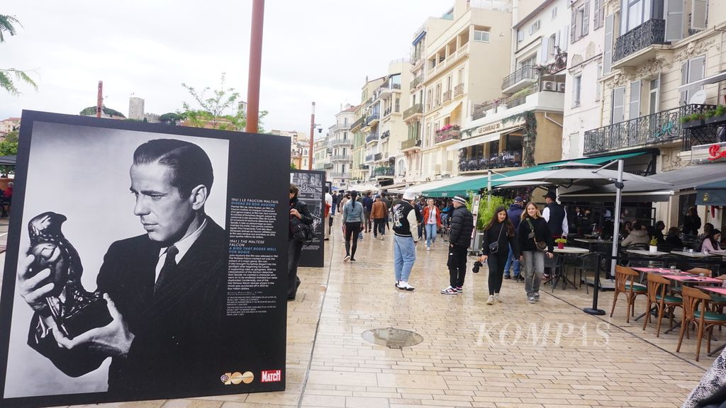 Para pejalan kaki di kawasan Allee de la Liberte Charles de Gaulle di Cannes, Perancis, disuguhi jajaran baliho berisi foto-foto lama para pemain film kelas dunia yang pernah tampil di Festival Film Cannes, Sabtu (20/5/2023).