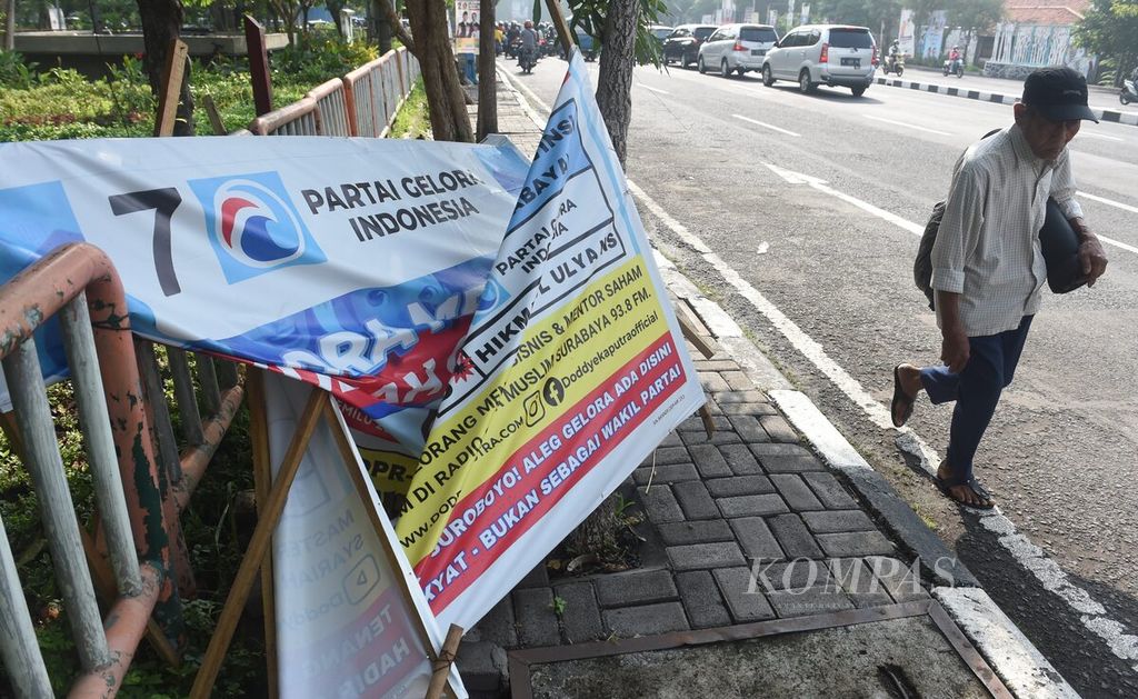Trotoar di kawasan Jemursari, Surabaya, Jawa Timur, terhalang <i>banner</i> salah satu calon anggota legislatif yang rusak, Jumat (29/12/2023). 