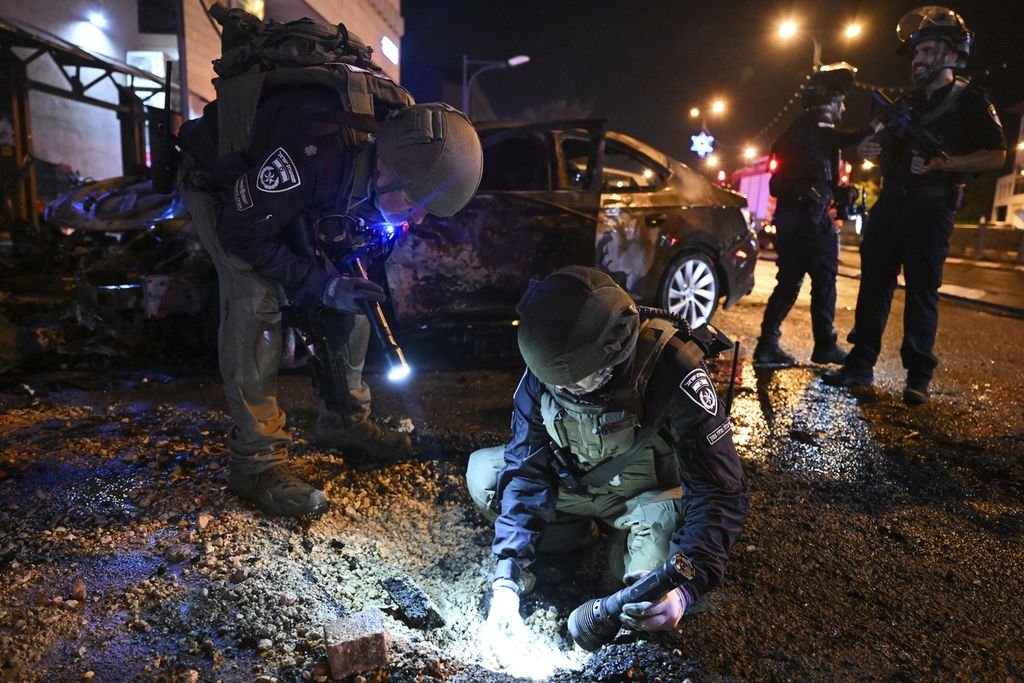 Polisi Isrel tengah mengamati lubang di sekitar lokasi ledakan di Kiryat Shmona, Israel utara, Kamis (2/11/2023).  