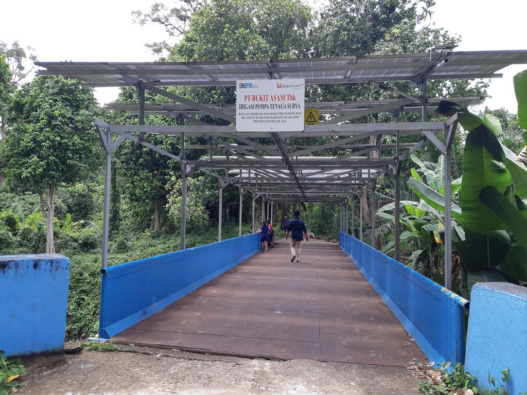 Panel surya yang dipasang di atas jembatan yang berada di Desa Tanjung Raja, Kecamatan Muara Enim, Kabupaten Muara Enim, Sumatera Selatan, Kamis (18/11/2021). Pembangkit listrik tenaga surya ini menghasilkan listrik untuk mengalirkan air dari Sungai Enim menuju ke areal persawahan warga di desa tersebut.