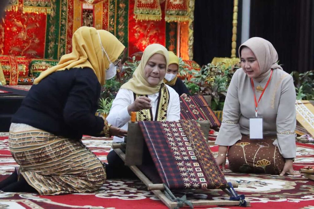 Ibu Negara Ny Iriana Joko Widodo mencoba membuat sulam tapis didampingi Ketua Dewan Kerajinan Nasional Daerah Lampung Riana Sari dan Desi Impiani, perajin tapis, di Mahan Agung, Bandar Lampung, Lampung, Rabu (8/3/2023). Kehadiran Iriana ke Lampung yang bertepatan dengan peringatan Hari Perempuan Internasional ini memberi semangat bagi para perempuan.