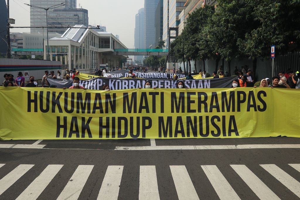 Para peserta aksi membentangkan spanduk di Jalan MH Thamrin, Jakarta, Minggu (27/11/2022). Aliansi Masyarakat Tolak RKUHP menggelar aksi dengan membentangkan spanduk bertuliskan kalimat kritik pada hari bebas kendaraan bermotor. 