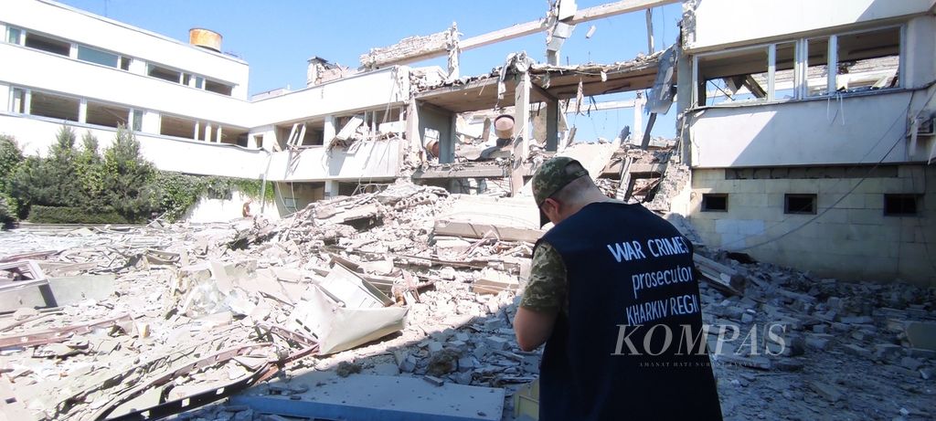 Penyelidik pada Kantor Penyelidikan Kejahatan Perang Cabang Kharkiv memeriksa dampak serangan Rusia terhadap kampus Universitas Pendidikan Nasional Kharkiv, Ukraina, Rabu (6/7/2022). Sebagian bangunan di kampus itu hancur setelah terkena rudal Rusia pada Rabu dini hari.