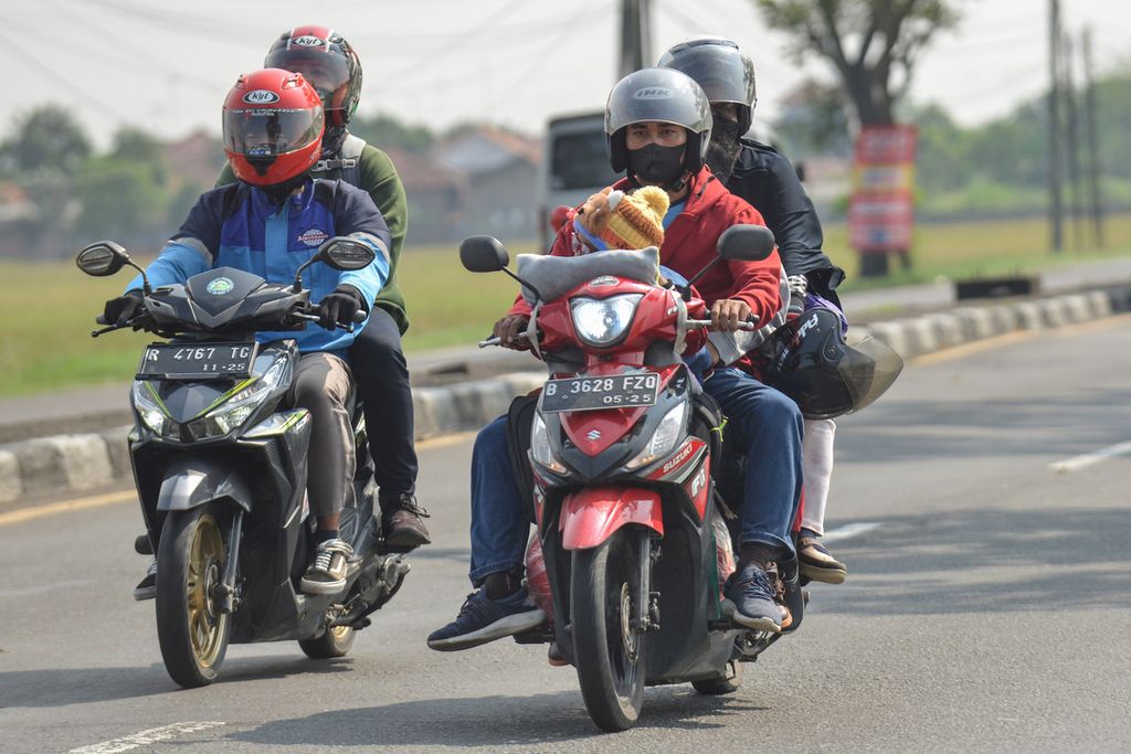 Pemudik membawa anaknya tanpa helm saat mengendarai sepeda motor di Jalan Raya Pantura, Ciasem, Kabupaten Subang, Jawa Barat, Rabu (19/4/2023).