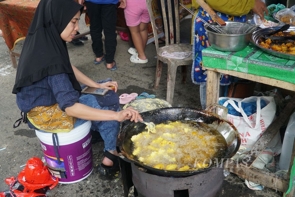 Pedagang menggoreng perkedel jagung di <i>pasa pabukoan</i> di pelataran parkir Ruang Terbuka Hijau Imam Bonjol, Kota Padang, Sumatera Barat, Jumat (24/3/2023) sore. 