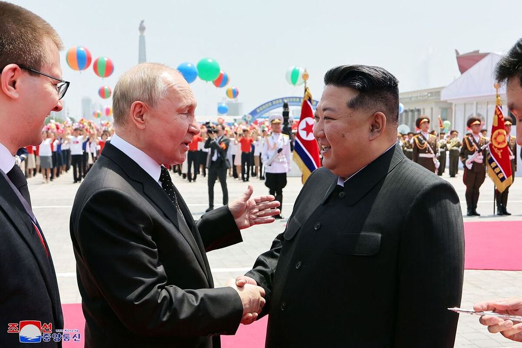 Foto yang diambil pada 19 Juni 2024 dan dirilis pada 20 Juni 2024 oleh kantor berita Korea Utara, KCNA, ini memperlihatkan Pemimpin Korut Kim Jong Un (kanan) berjabat tangan dengan Presiden Rusia Vladimir Putin dalam upacara penyambutan di Lapangan Kim Il Sung di Pyongyang, Korut. 