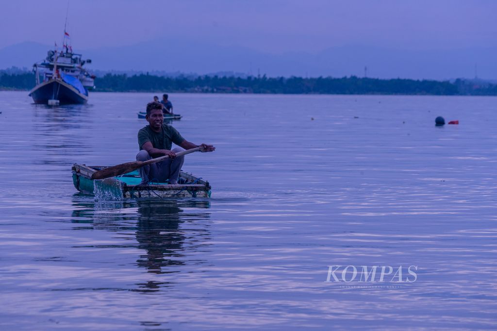 Sejumlah warga yang juga nelayan membawa barang untuk dipindahkan ke kapal di Teluk Kendari, Sulawesi Tenggara, Senin (28/3/2022). Nelayan kecil di wilayah ini menghadapi berbagai tantangan, utamanya dengan konflik jalur penangkapan yang telah diatur pemerintah.