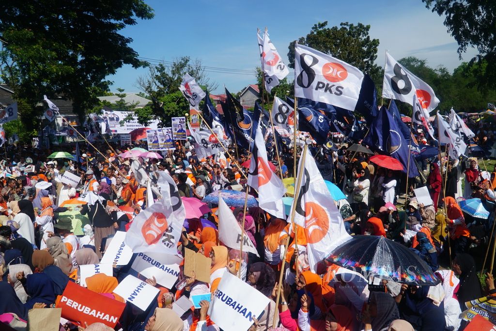 Massa mengibarkan bendera PKS dan Partai Nasdem dalam kampanye terbuka calon presiden Anies Baswedan di halaman GOR Haji Agus Salim, Kota Padang, Sumatera Barat, Kamis (25/1/2024). 