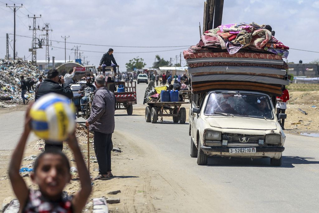 Palestinian refugees are flocking to leave Rafah in the southern Gaza Strip and arriving in Khan Younis on May 6, 2024, carrying their belongings following an ultimatum from the Israeli army to leave Rafah.